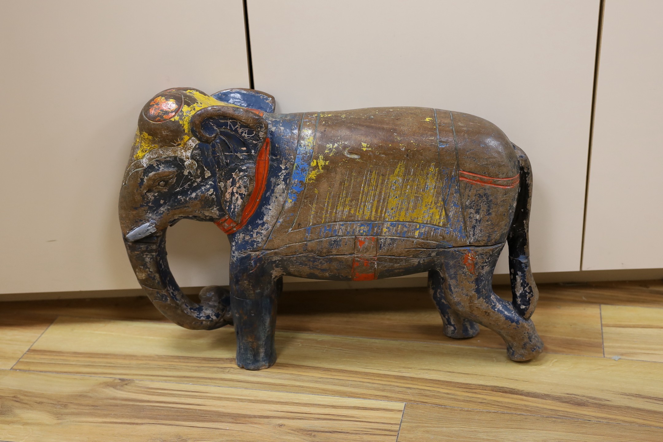 A large painted Indian hardwood elephant. 63cm wide